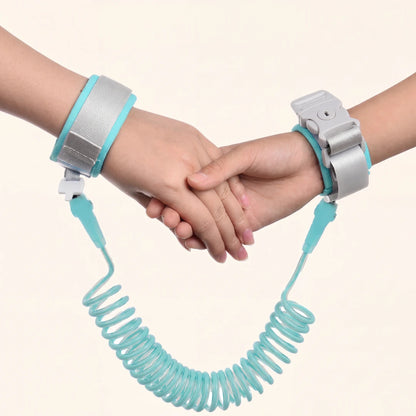 Two hands holding each other, connected by a teal coiled child safety wrist link