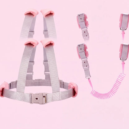 Toddler wearing the pink child safety harness with coiled leash, side view