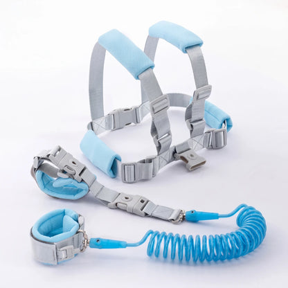 Toddler walking outdoors wearing the blue child safety harness with parent holding the leash